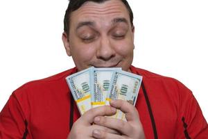 Glücklicher Mann hält Geld in seinen Händen und atmet ihren Duft ein foto