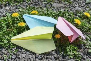 bunte papierflugzeuge der kinder auf dem gras foto