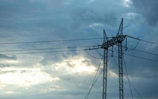 Stromleitungen am Himmel mit Wolken bedeckt foto