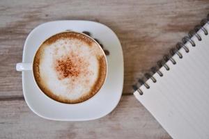 Cappuccino-Kaffee mit Notizbuch foto