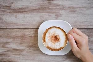 frauenhände, die latte art, kaffeetasse halten foto