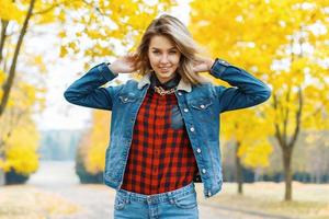 junge Frau in Jeanskleidung im Herbstpark. foto