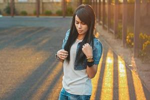 schönes Mädchen in einer Jeansjacke im Sonnenlicht Sonnenuntergang. foto