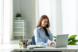 asiatische Geschäftsfrau, die im Büro am Laptop arbeitet. foto