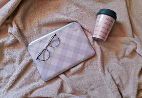 Laptop und Brille auf dem Handtuch foto