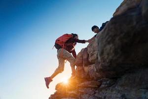 junge asiatische paare, die auf den berg klettern, wandern und teamarbeitskonzept. foto