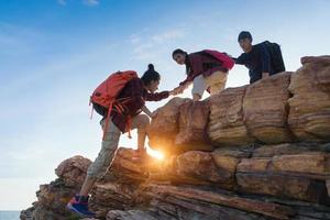 junge asiatische paare, die auf den berg klettern, wandern und teamarbeitskonzept. foto