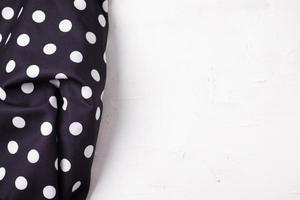 Polka Dot schwarze Serviette auf einer hölzernen Küchentischansicht von oben mit Kopienraum foto