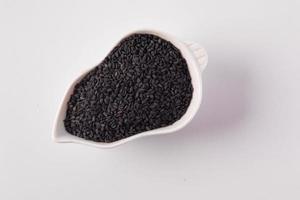 schwarzer Sesam in weißer Keramiktasse foto