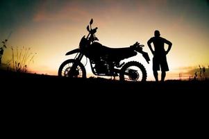 Herren-Silhouetten und Touren-Motocross-Bikes. Park zum Entspannen in den Bergen am Abend. abenteuerreise- und freizeitkonzept foto