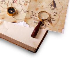 Kompass, Lupe und Karte auf dem Buch foto