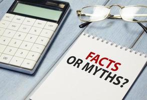 Wörter schreiben Text Fakten Mythen auf dem weißen Notizblock und Taschenrechner foto