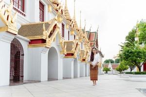 junge asiatische frau, die meditationsheiligtum ratchanatdaram bangkok geht foto