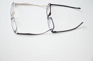 Brille zur Sehkorrektur mit offenen Pfeilen, die in einer Reihe auf weißem Hintergrund liegen. Optik, Fassungen, Zubehör, Augenheilkunde. foto