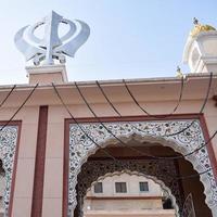 khanda sikh heiliges religiöses symbol am gurudwara-eingang mit strahlend blauem himmel bild wird bei sis ganj sahib gurudwara in chandni chowk gegenüber dem roten fort in alt-delhi indien aufgenommen foto