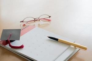 Stift auf Kalender und Graduierungskappe foto