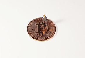 geschäftsmannfigur, die auf bitcoin steht. Bitcoin-Mining-Konzept. foto