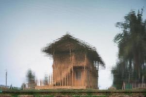 Antikes Holzhaus Reflexion über Teich foto