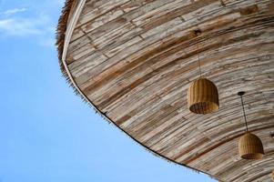 Strohdach aus Holz mit hängender Lampe und Himmel foto