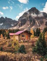 Holzhütte mit felsigen Bergen im Herbstwald im Nationalpark foto