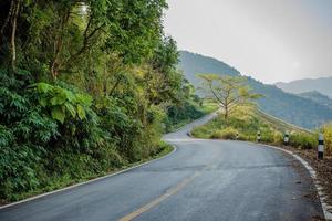 gebogene asphaltierte straße in den bergen der provinz chiang rai, thailand foto