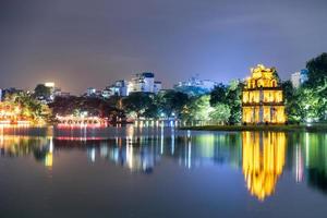 goldener schildkrötenturm mit der huc-roten brücke im hoan-kiem-see bei nacht foto