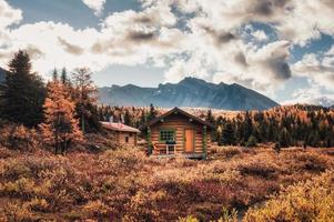 Holzhütten mit felsigen Bergen im Herbstwald im Assiniboine Provincial Park foto