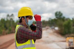 Vorarbeiter in Uniform mit Helm auf Straßenbaustelle foto