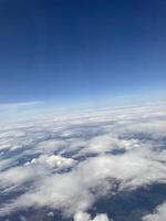 Blick auf die Wolken aus dem Flugzeug. weiße wolken gegen den blauen himmel nahaufnahme. schöne luftaufnahme der wolken foto