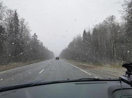 Schnee fällt auf die Straße, um die Autos zu treffen foto