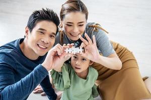 glückliche familie, asiatische kleine tochter, die puzzle mit ihrer mutter und ihrem vater für familienkonzept spielt, sie bauen puzzle zusammen. foto