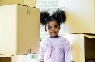 Lieferdienste verlagern. glück liefern, afroamerikanisches süßes babymädchen spielen gerne mit pappkarton zu hause, versicherungspostpaket. liefern Sie Ihre Schätze. Aufbewahrung für Spielzeug. foto
