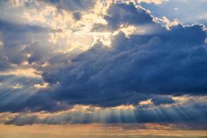 sonnenstrahlen und wolken, sonnenstrahlen, die durch kumuluswolken scheinen, atemberaubende szene des naturphänomens foto
