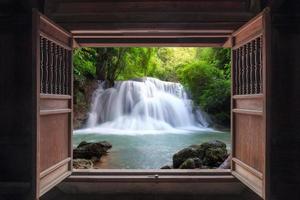 Öffnen Sie die alte Holztür zum Wasserfall foto