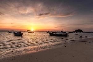 Hölzerne Long-Tail-Boote auf tropischem Meer bei Sonnenaufgang am Morgen foto
