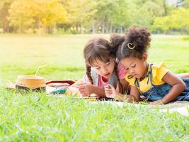 eine Gruppe kleiner Kinder vieler Nationalitäten spielt und lernt außerhalb der Schule foto