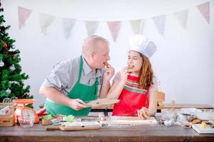 ein junges europäisches mädchen und ihr vater testen die lebkuchen, die sie zu weihnachten und neujahr macht foto