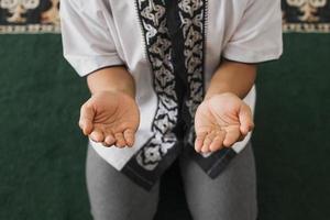 draufsicht die hand eines muslimischen mannes betet zu allah in der moschee foto