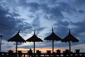 Sommerferien. Einige Leute entspannen sich am Strand der Liege und genießen die Sonnenuntergangszeit. kopierraum für reise- und lifestyle-konzept foto