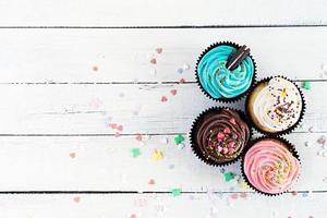 Leckere bunte Cupcakes isoliert auf Holzhintergrund. leckerer Kuchen foto