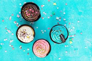 leckere bunte Cupcakes isoliert auf blauem Hintergrund. leckerer Kuchen foto