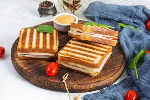Club-Sandwich mit Schinken, Tomate, Käse und Spinat. gegrillte panini foto