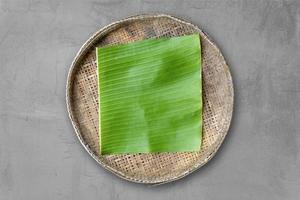 grüne Bananenblätter auf einem Bambustablett foto