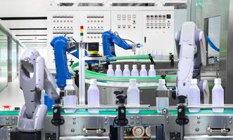 Roboterarm, der Wasserflaschen auf der Produktionslinie in der Fabrik hält, Industrie 4.0-Konzept foto