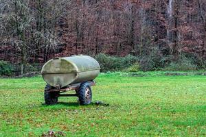 Fassanhänger in einem Feld, umgeben von herbstlichen Pflanzen foto