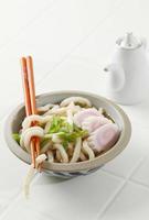 japanisches udon auf asiatischer zementschale, auf weißem tisch foto