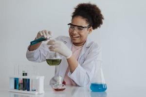 Afroamerikanische Studentin, die im naturwissenschaftlichen Unterricht ein chemisches Experiment lernt. glückliches afrikanisches mädchen, das chemielabor lernt und macht. Bildungs- und Wissenschaftskonzept. foto