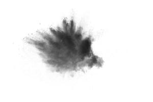 Explosion von Schwarzpulver. die Kohlepartikel spritzen auf weißem Hintergrund. nahaufnahme von schwarzen staubpartikeln spritzen isoliert auf hintergrund. foto