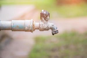 Wassertropfen im Wasserhahn, auslaufendes Wasser foto