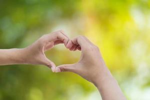 Hand der Liebe auf grünem Bokeh-Hintergrund foto